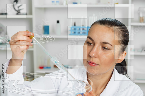 Young Female Scientist Analyzing Sample In Laboratory.laboratory assistant analyzing a sample
