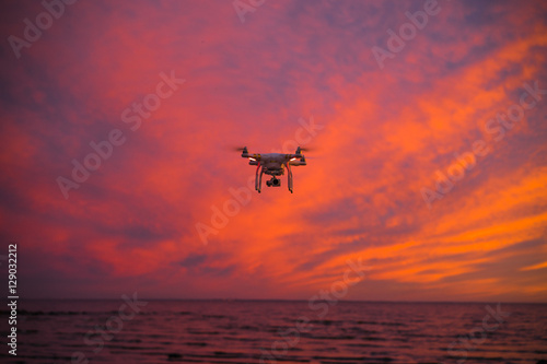 Flying drone on the sunset beach