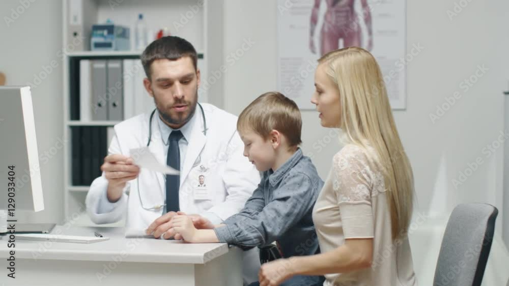 Male Doctor Writes a Prescription to a Young Boy and His Motherand. Gives Prescriptionto Mother with Some Oral Recommendations. Shot on RED Cinema Camera in 4K (UHD). Male Doctor Writes a Prescription to a Young Boy and His Motherand. Gives Prescriptionto Mother with Some Oral Recommendations. Shot on RED Cinema Camera in 4K (UHD).