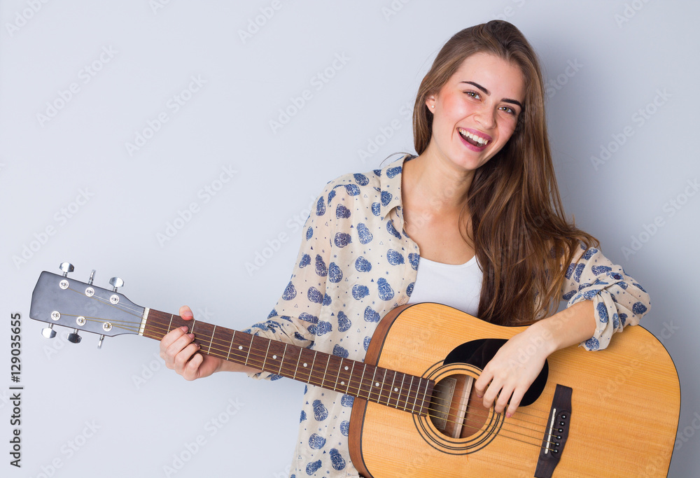 Fototapeta premium Young woman holding a guitar 