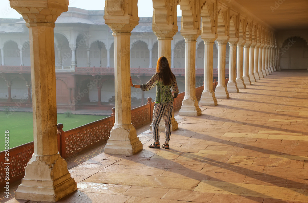 Fototapeta premium Young woman standing in colonnade walkway leading to Diwan-i- Kh