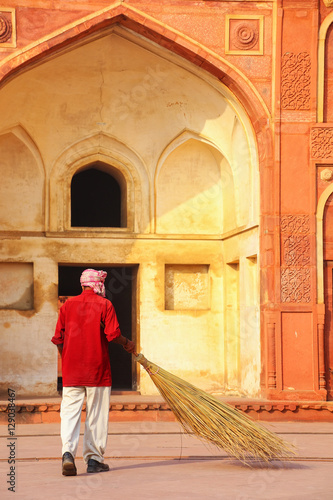 Local worker sweeping courtyard of Jahangiri Mahal in Agra Fort,