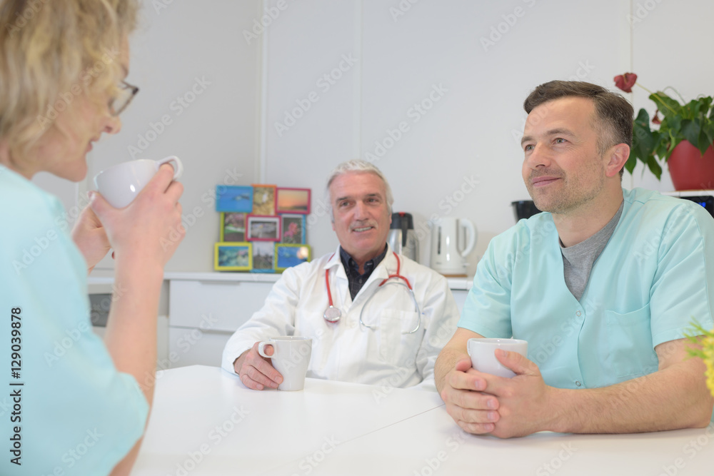 Fototapeta premium male and female doctors talking to nurse on work break
