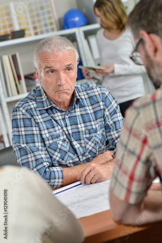 Man in meeting with couple, bemused facial expression