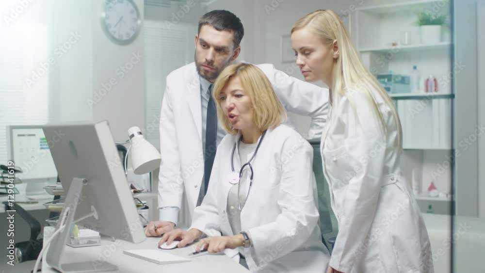 Group of Three Medical Specialists Solving Problems at the Desktop Computer. They Gesticulate and Point at the Screen. Shot on RED Cinema Camera in 4K (UHD). Group of Three Medical Specialists Solving Problems at the Desktop Computer. They Gesticulate and Point at the Screen. Shot on RED Cinema Camera in 4K (UHD).