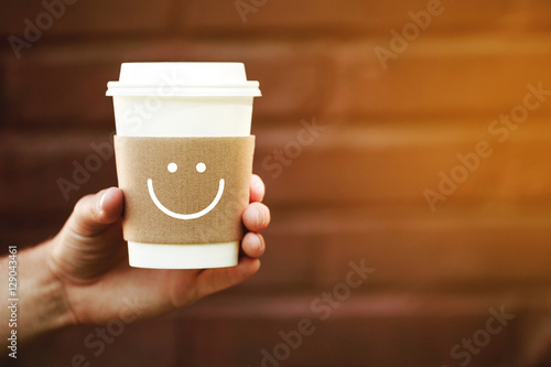 Paper cup of happy takeaway coffee in the hand