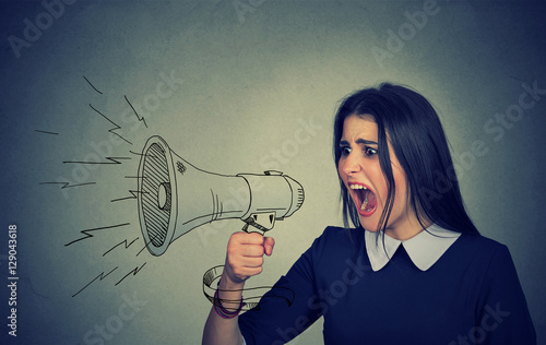 Angry young woman screaming in megaphone