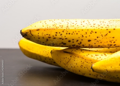 Bunch of bananas lying on dark wooden table