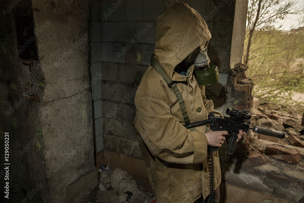 young boy stands with a gun in his hand. boy in a gas mask. boy in a protective cloak and hood. child standing near the destroyed building. a child soldier. young boy soldiers. laser tag game.
young boy stands with a gun in his hand. boy in a gas mask. boy in a protective cloak and hood. child standing near the destroyed building. a child soldier. young boy soldiers. laser tag game.