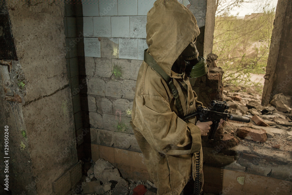 young boy stands with a gun in his hand. boy in a gas mask. boy in a protective cloak and hood. child standing near the destroyed building. a child soldier. young boy soldiers. laser tag game.
young boy stands with a gun in his hand. boy in a gas mask. boy in a protective cloak and hood. child standing near the destroyed building. a child soldier. young boy soldiers. laser tag game.
