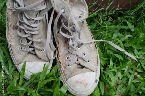 .Lack of old shoes Placed on the beautiful green grass.