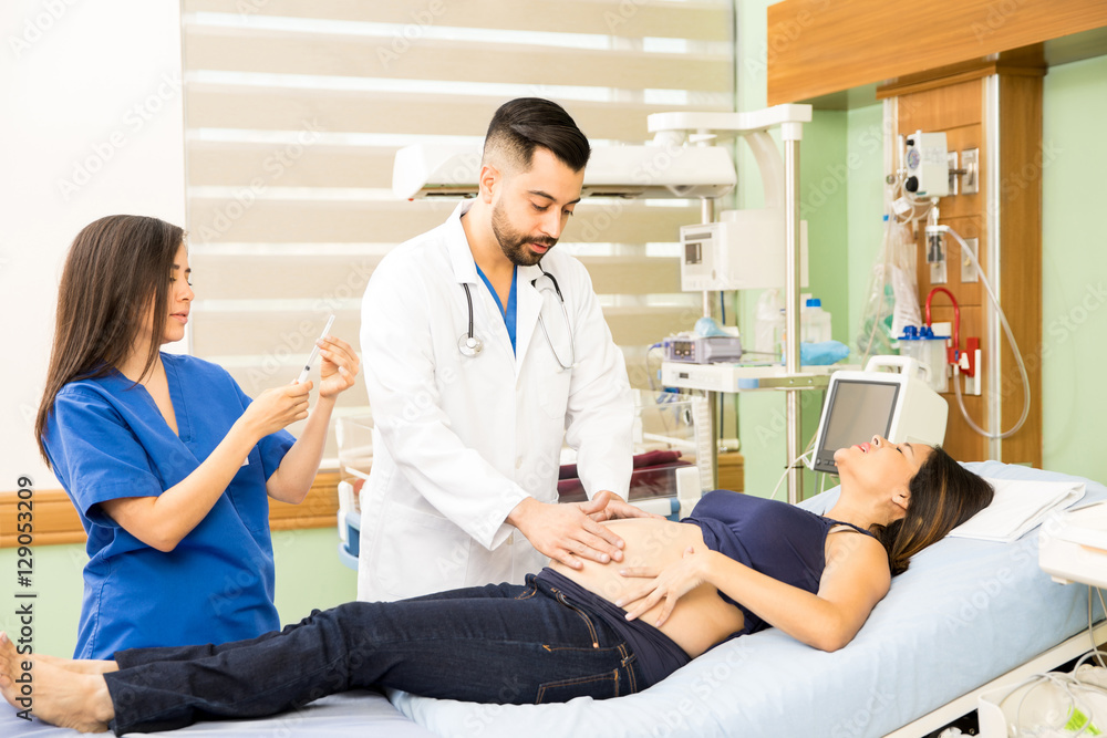 Obraz premium Doctors taking care of pregnant woman