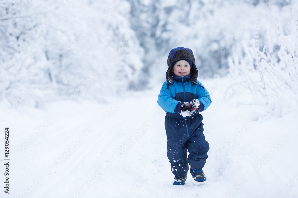 Happy caucasian child playing in snow Happy caucasian child playing in snow