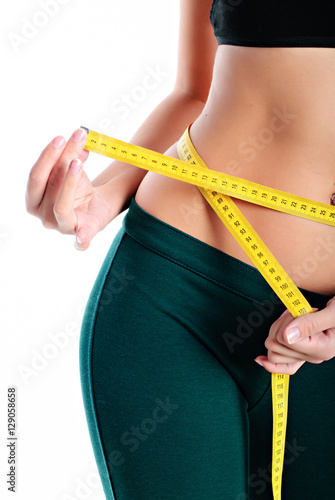 Hands measuring waist with a tape. Slim and healthy woman on white background