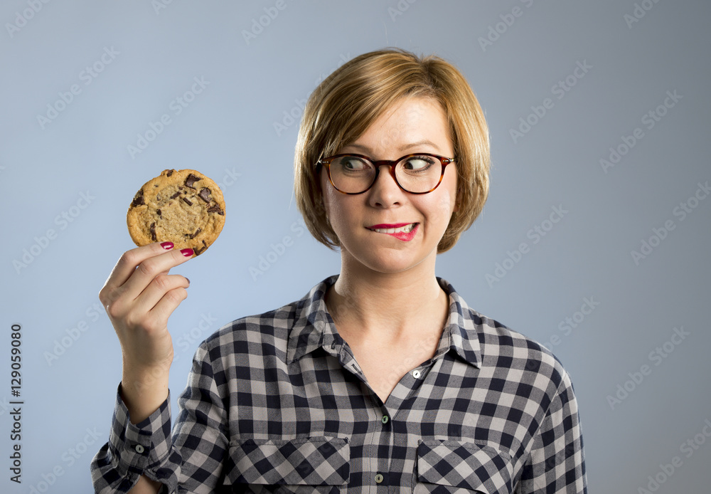 young blond cute and friendly caucasian woman in casual clothes holding big delicious chocolate cookie young blond cute and friendly caucasian woman in casual clothes holding big delicious chocolate cookie