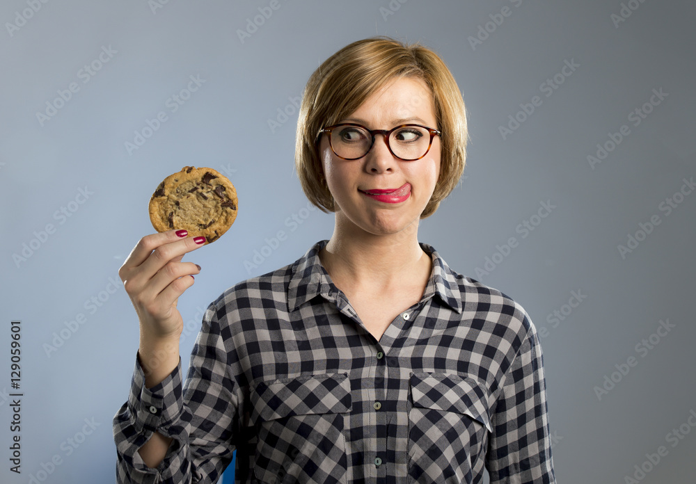 young blond cute and friendly caucasian woman in casual clothes holding big delicious chocolate cookie young blond cute and friendly caucasian woman in casual clothes holding big delicious chocolate cookie