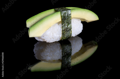 Sushi nigiri with avocado on black background with reflection. J