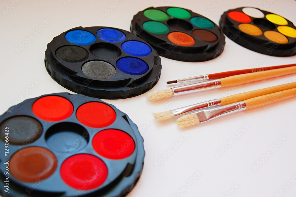 watercolor palettes and classic wooden paint brushes on white background watercolor palettes and classic wooden paint brushes on white background