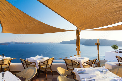 Obraz na płótnie restaurant on terrace with view on sea, Santorini island, Cyclades, Greece w salonie