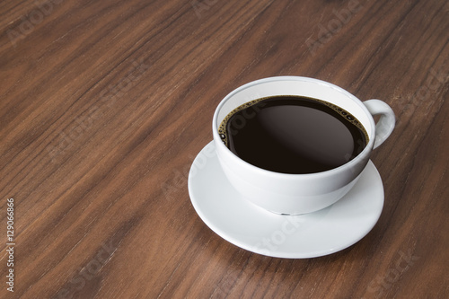 white coffee cup and hot espresso coffee on wooden table.