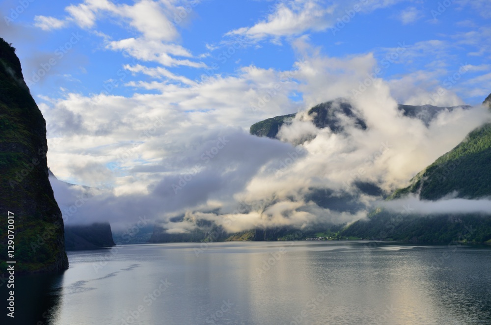 Cloudy mountains with fjord in foreground