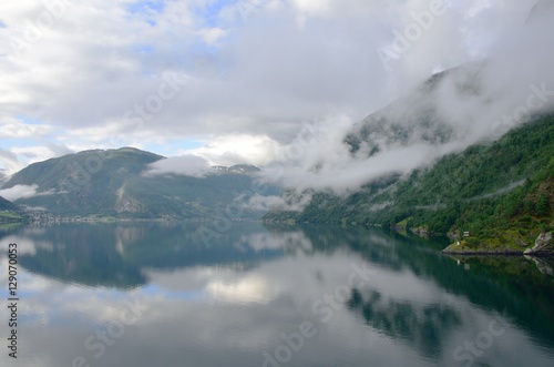 Still Norwegian fjord with cloudy sky
