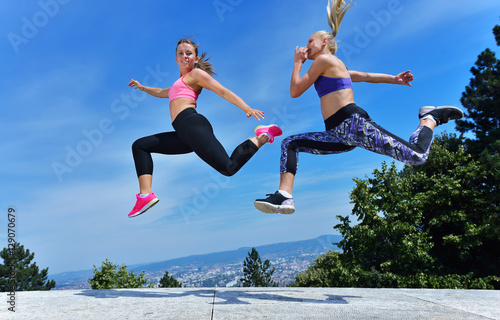 Two happiness young women jumping over blue sky © FS-Stock