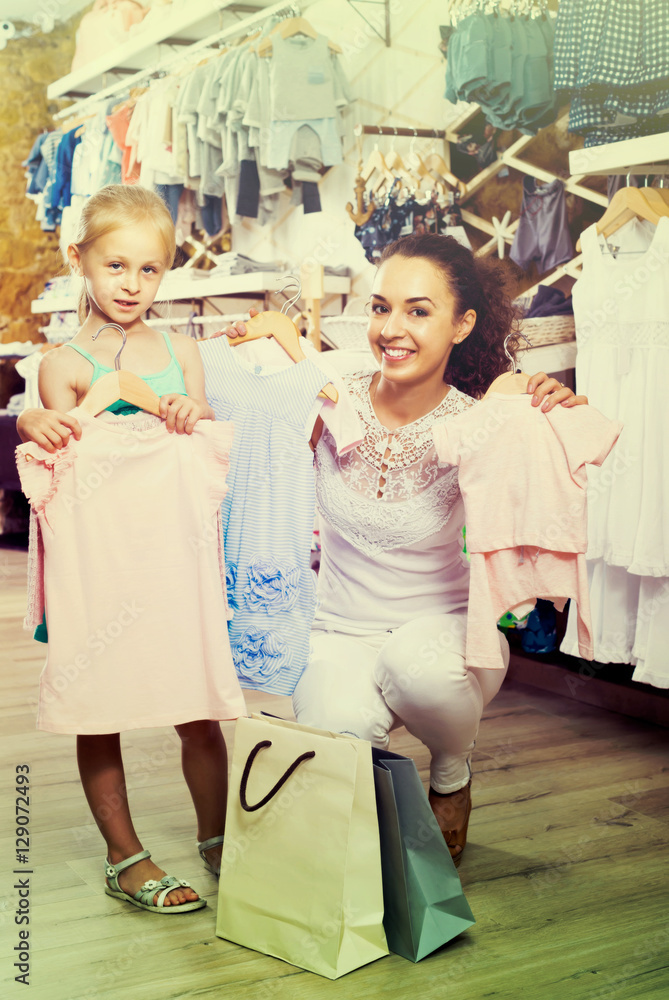 portrait of  woman and girl shopping kids apparel in clothes sto