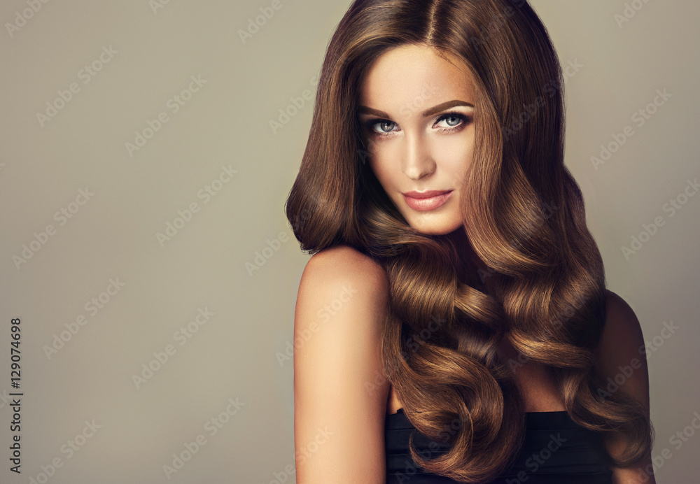 Beautiful model girl with long wavy and shiny hair . Brunette woman with  curly hairstyle Stock Photo | Adobe Stock