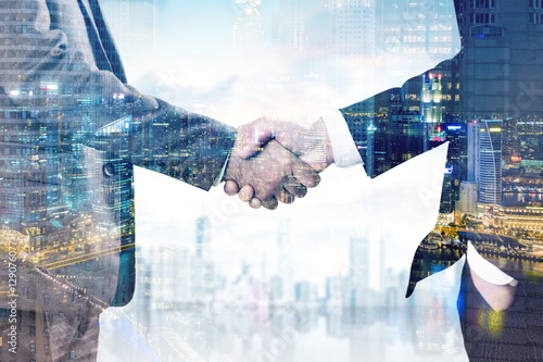 Close up of two businessmen's hands. Two cities photo