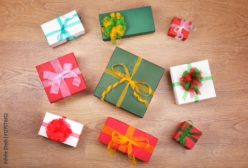 Lovely Christmas presents located on wooden board background.