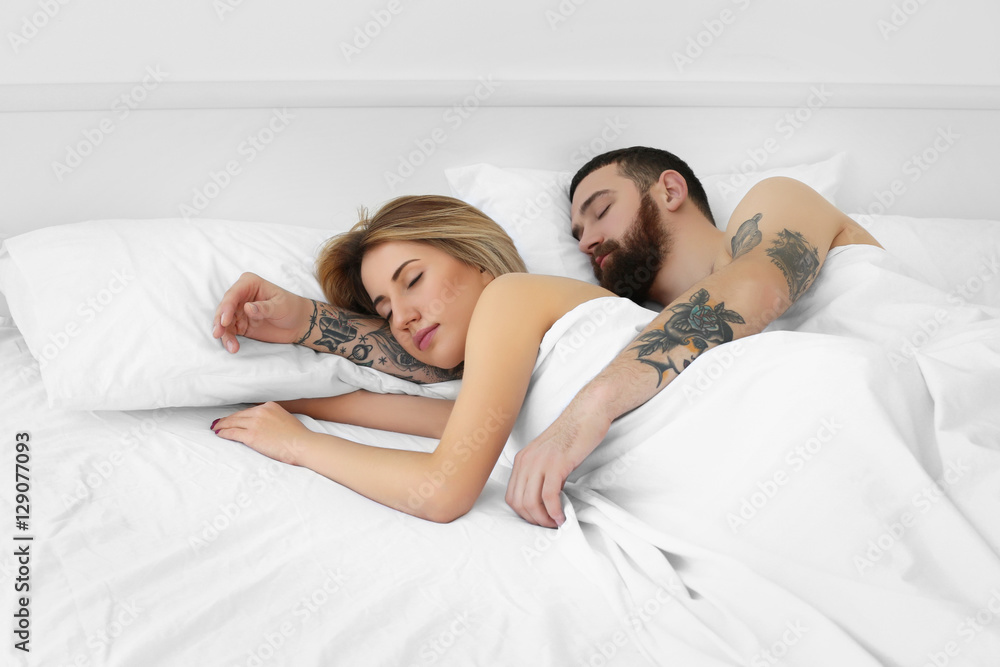 Tattooed couple sleeping in bed Tattooed couple sleeping in bed