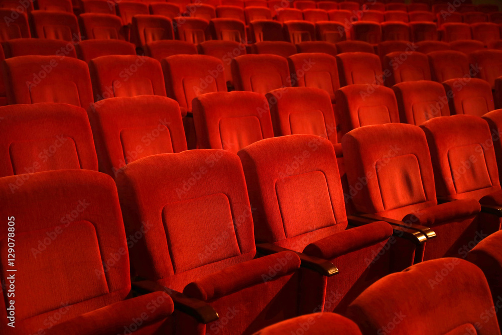  Red colored empty movie theater chairs in row