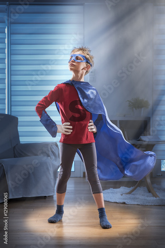 Little boy dressed as super hero in his living room
