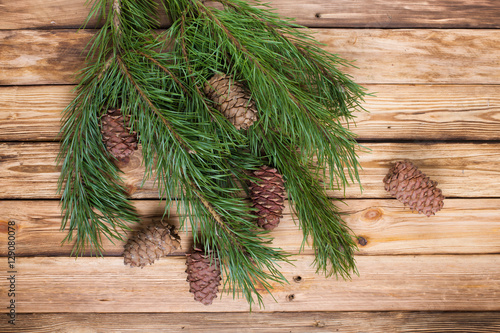 Pine branches with cones on wooden table