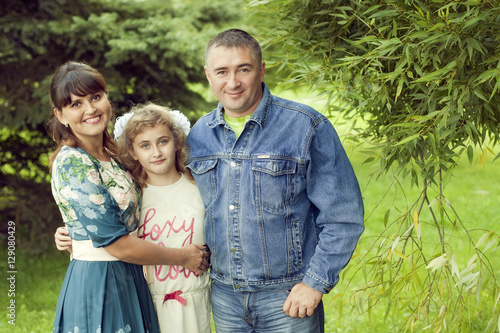 A normal happy family posing in the Park mom, dad and daughter 1