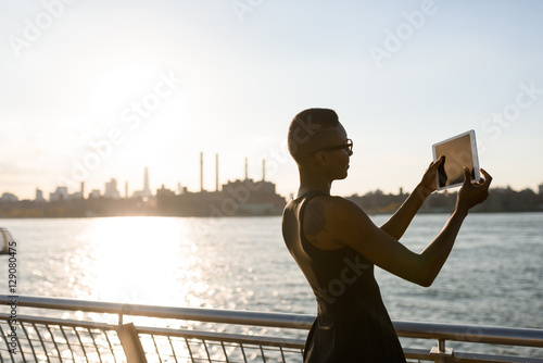African business woman working on the tablet outdoor, close up, New York, Manhattan, skyline view