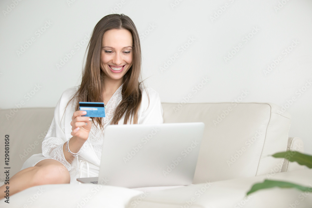 Young smiling woman paying with a card for holiday, hotel and flights, supermarket shopping, car renting, having good personal, home budget Young smiling woman paying with a card for holiday, hotel and flights, supermarket shopping, car renting, having good personal, home budget