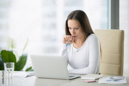 Young serious businesswoman working at the modern office desk with laptop, nervous breakdown, waiting for interview, exam, medical test result, financial issues anxiety, single woman depression