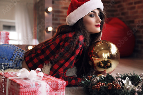 charming woman with dark hair posing near Christmas tree photo