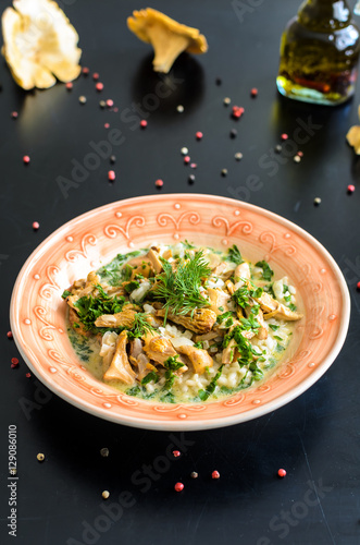 Delicious risotto with porcini mushrooms over rustic black background