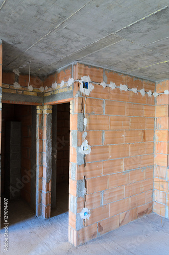 Electric sockets installation in brick walls at house construction site © ognjeno