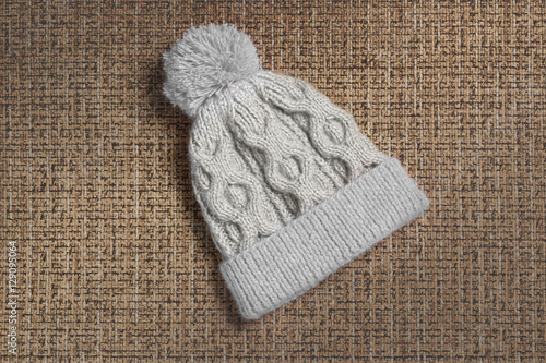 Knitted cap with a pompon of wool mixture