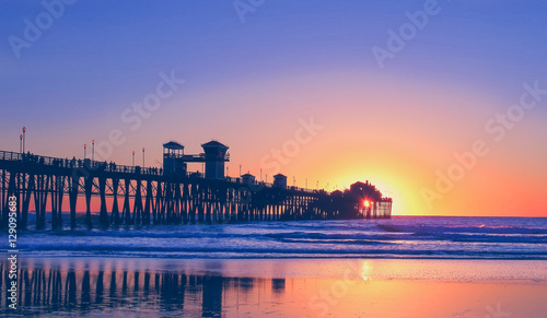 Vintage beach photo of pier at sunset in California 