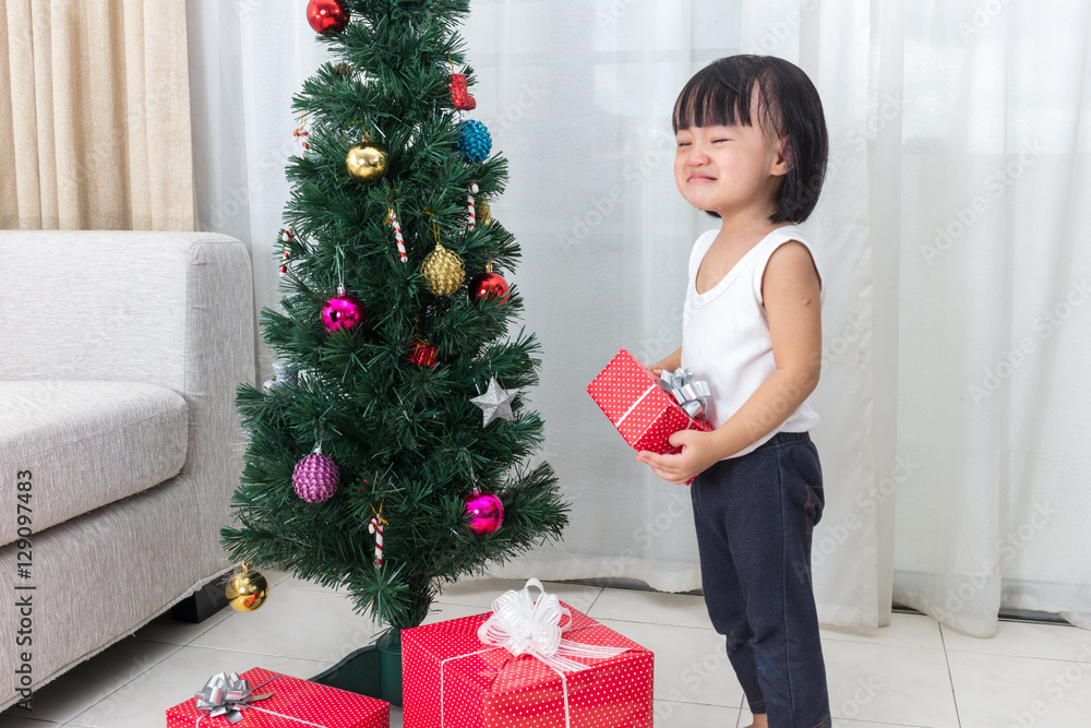 Asian Chinese little girl crying beside Christmas tree Asian Chinese little girl crying beside Christmas tree