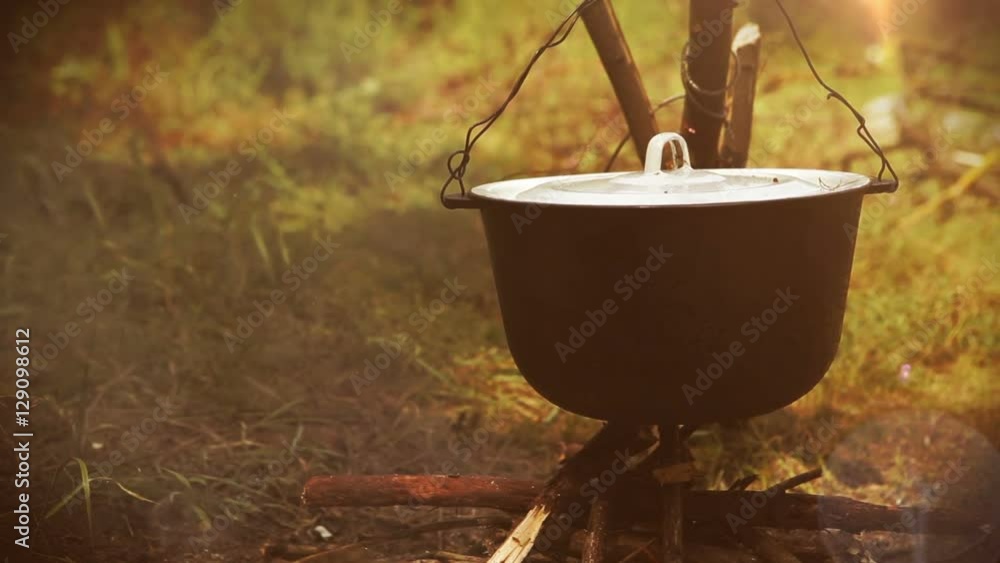 Campfire scene: a pot with food hangs over the fire Campfire scene: a pot with food hangs over the fire