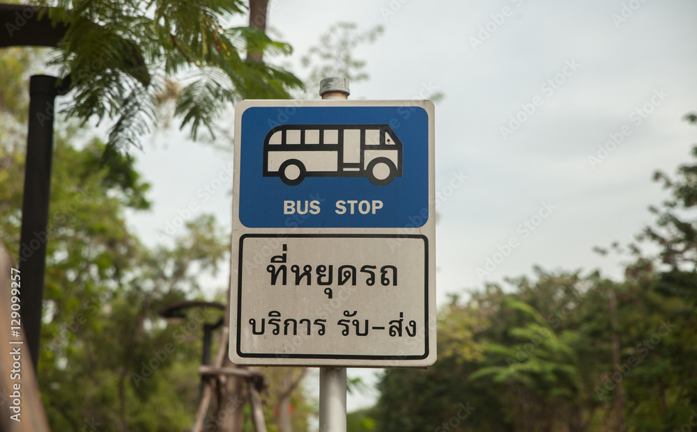 Bus stop sign on pole next to the road