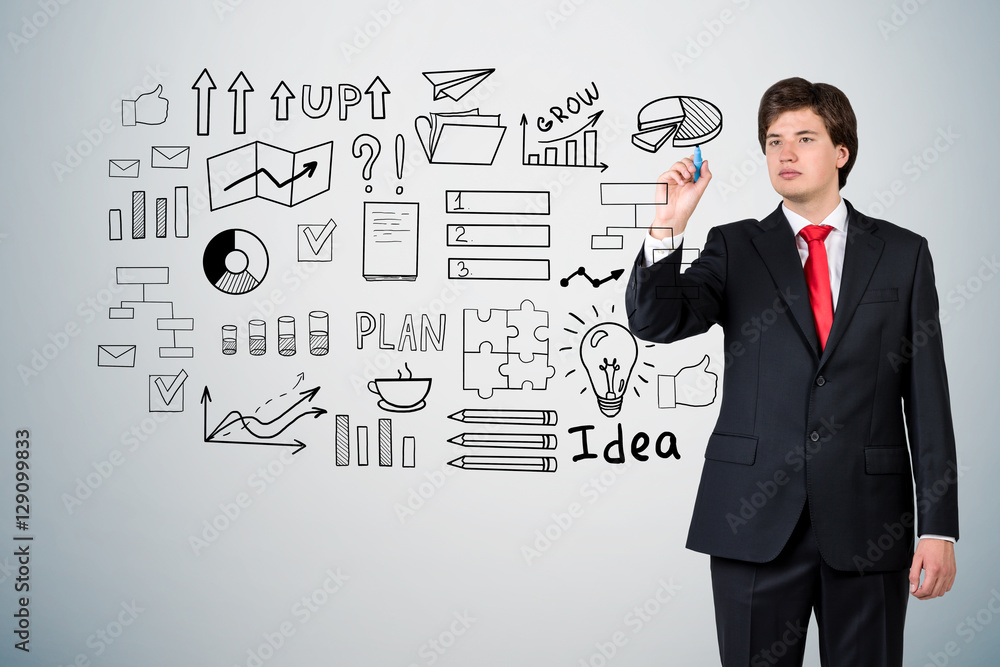 Businessman in a suit is drawing a startup idea sketch on a glas Businessman in a suit is drawing a startup idea sketch on a glas