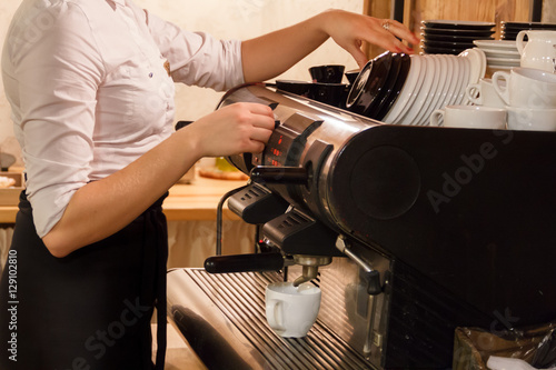 Billede på lærred Woman preparing coffee on coffeemaker