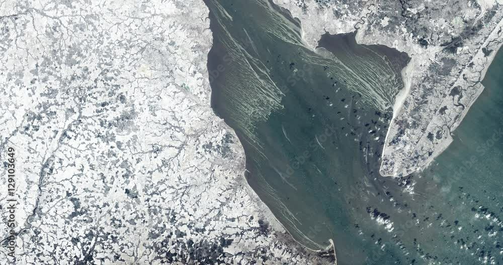 High-altitude overflight aerial of a frozen Delaware Bay on the East Coast. Clip loops and is reversible. Elements of this image furnished by USGS/NASA Landsat 

